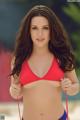 A woman in a red bikini standing on a beach.