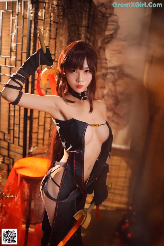 A woman in a black and red outfit holding a sword.
