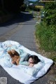 A little girl laying on a blanket with a teddy bear.