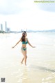 A woman in a blue bikini standing in the water.