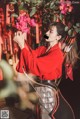 A woman in a red kimono holding a bow and arrow.