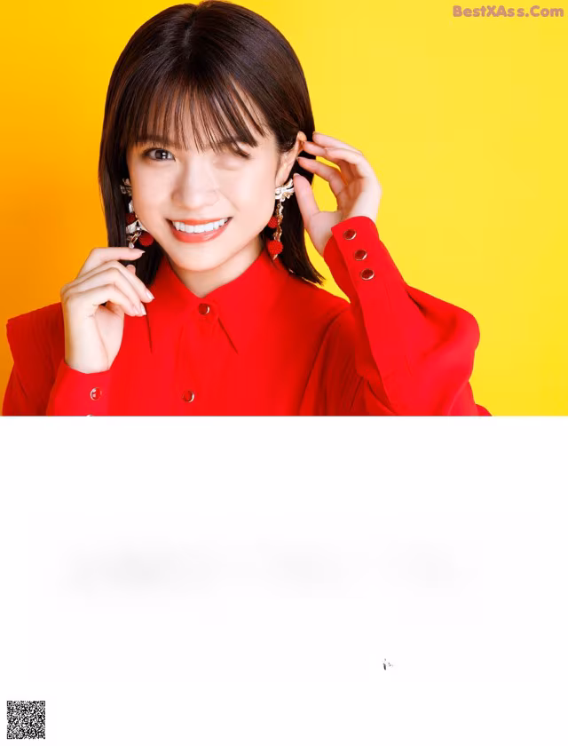 A woman in a red shirt is posing for a magazine.